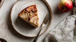 Sourdough discard apple cake slice on rustic ceramic plate with tea